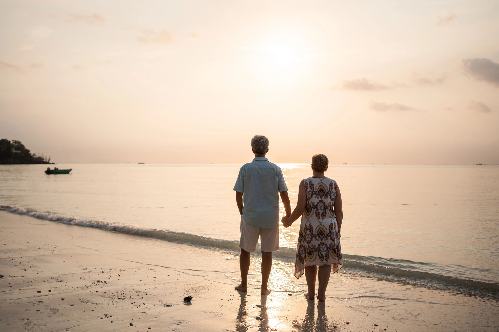 Couple holding hands at the beach at sunset