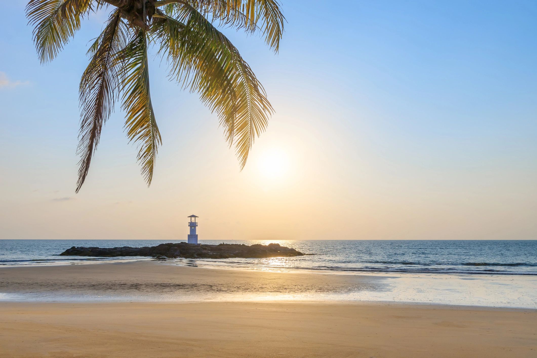 Khao Lak beach with lighthouse and palm leaves
