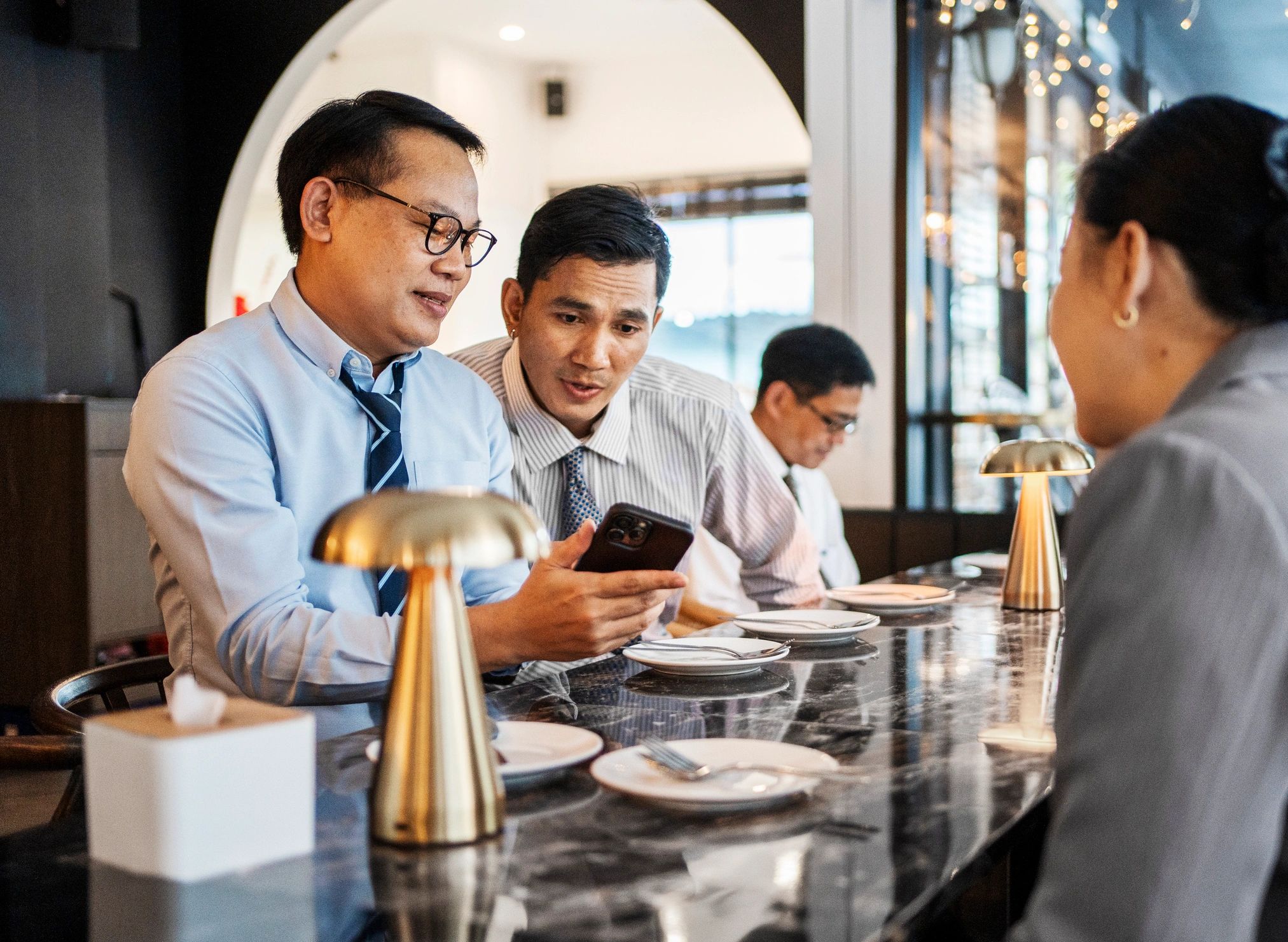 Two guests reviewing details on a phone for testimonial avatar