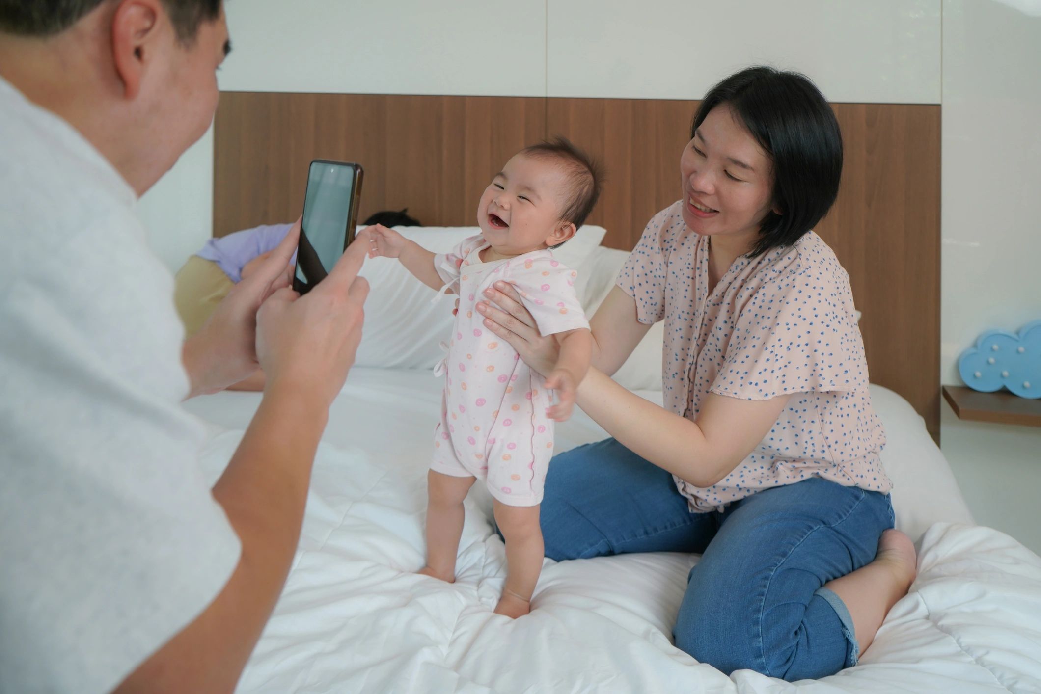 Parent taking a photo of a baby with mom